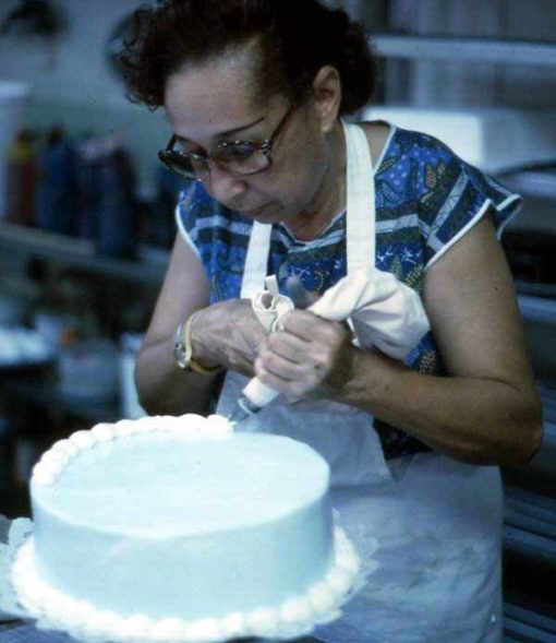 Cuban American woman decorating a cake at the Cafe Cubano in Little Havana - Miami, Florida.