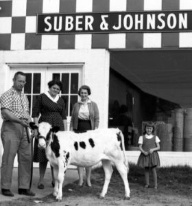 A family poses with a Holstein calf.